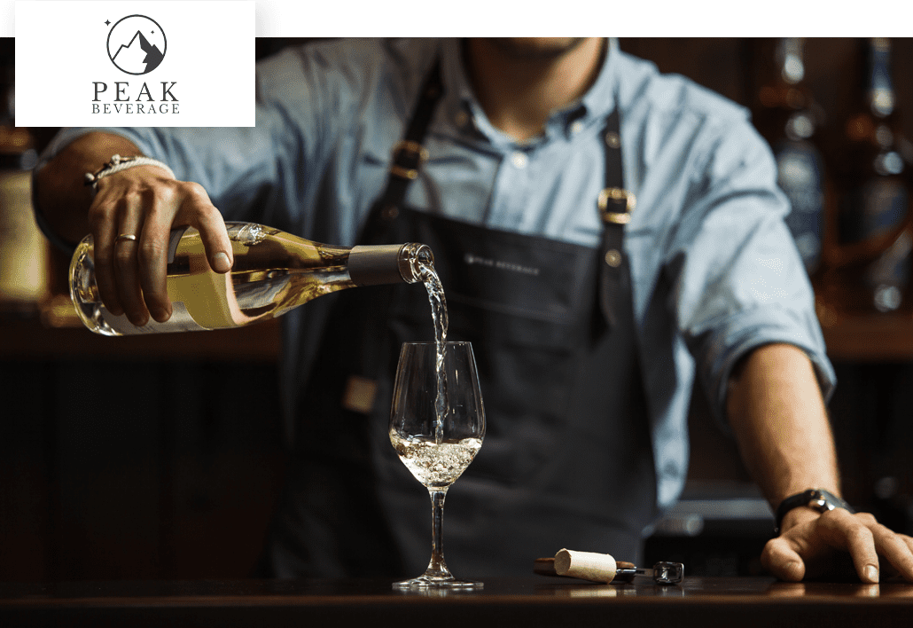 Peak Beverage bartender pouring white wine